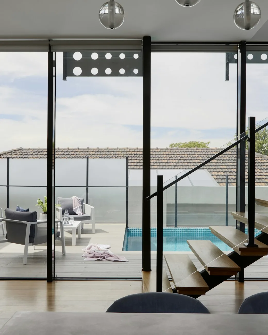 Contemporary open-plan interior with glass partition and soft coastal light