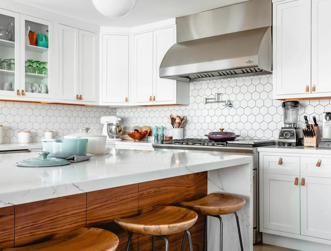 Sunlit white kitchen with a centred island and timber stools