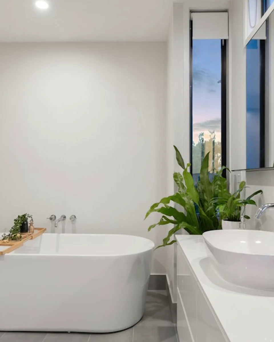 Freestanding bath against pale stone and timber details